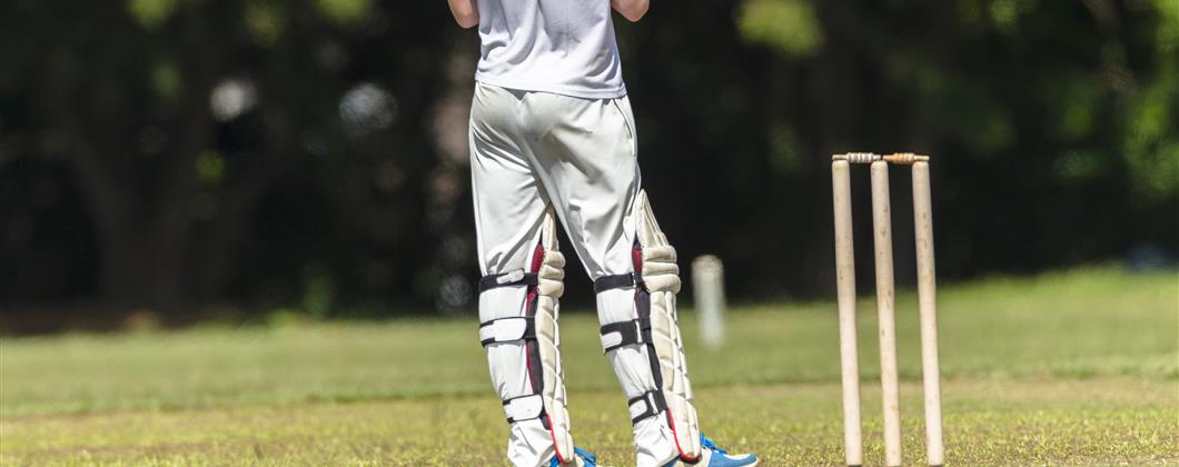 Gentleman waiting to play cricket standing next to wicket 